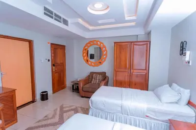 a living room with a bed and a couch at Selig Hotel in Moshi