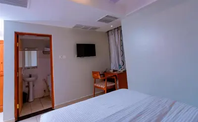 a hotel room with a bed and a bathroom at Selig Hotel in Moshi