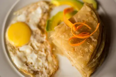a plate of food with an egg and vegetables at KILEMAKYARO Mt LODGE in Uru