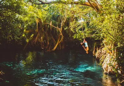 a man jumping into a river in the jungle at KILEMAKYARO Mt LODGE in Uru