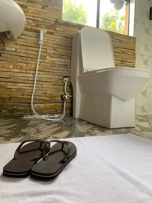 a pair of sandals sitting on a bed next to a printer at Peakline Apartments in Arusha