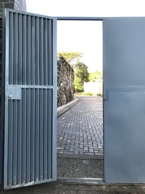 an open door leading to a brick road at Peakline Apartments in Arusha