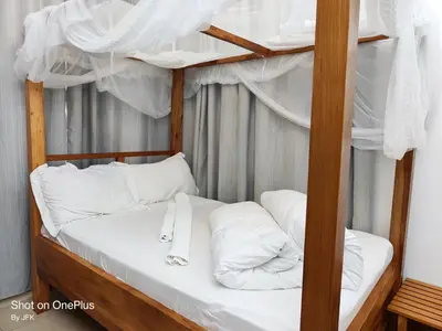 a bunk bed with white sheets and pillows on it at Twiga Luxe in Arusha