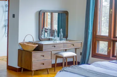 a bathroom with a sink and a mirror on a dresser at Moonbow lodge in Mto wa Mbu
