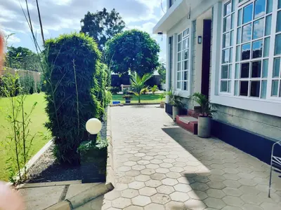 a walkway next to a house with plants at Garden View with detached Bathroom in Arusha