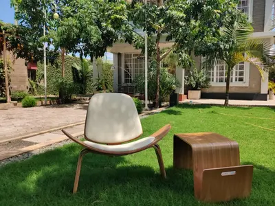 a chair and a stool in a yard at Garden View with detached Bathroom in Arusha