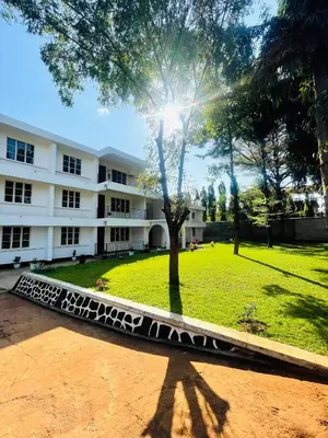 a building with a tree in the middle of a park at Mahali House in Moshi