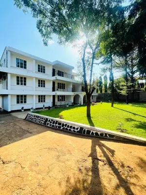 a large white building with a tree in front of it at Mahali House in Moshi