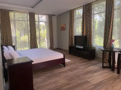 a bedroom with a bed and a flat screen tv at Serene Vacay Hotel Marangu in Marangu