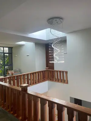 a lobby with a staircase and a chandelier at Serene Vacay Hotel Marangu in Marangu