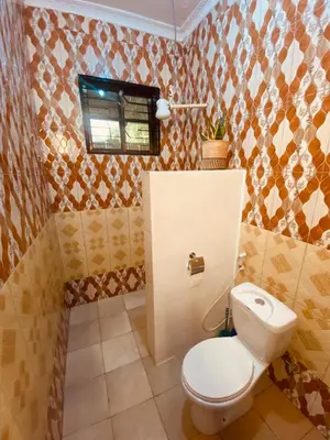 a bathroom with a white toilet in a room at Tukutane Kilimanjaro - Homestay in Uru