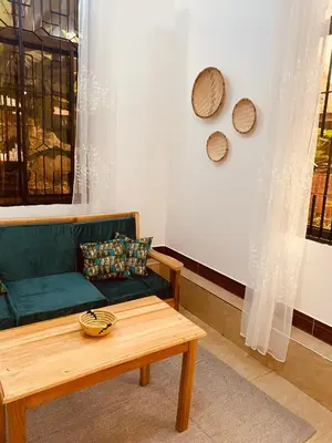 a living room with a green couch and a coffee table at Tukutane Kilimanjaro - Homestay in Uru