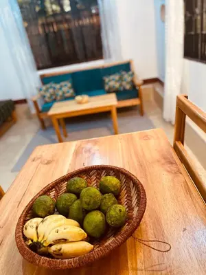 a bowl of fruit sitting on a table with bananas at Tukutane Kilimanjaro - Homestay in Uru