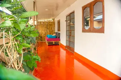 a living room with a red floor and a chair at Moshi hostel lodge in Msaranga