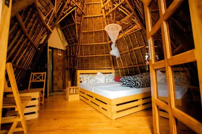 a bedroom with a bed in a straw hut at Moshi hostel lodge in Msaranga
