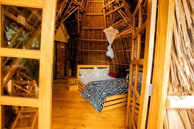 a bedroom with a bed in a room with wooden floors at Moshi hostel lodge in Msaranga