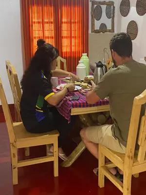 a man and a woman sitting at a table at Moshi hostel lodge in Msaranga