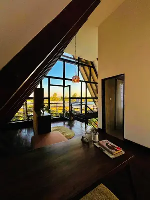 a living room with a staircase and a room with a table at Sereno Cabana in Arusha