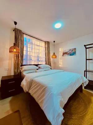 a bedroom with a large bed and a window at Sereno Cabana in Arusha