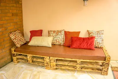 a wooden bench with colorful pillows on a wall at Moshi hostel lodge TANZANIA in Moshi