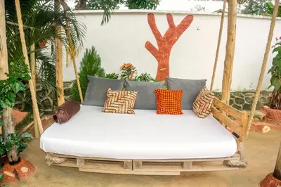 a porch swing with pillows on it at Moshi hostel lodge TANZANIA in Moshi