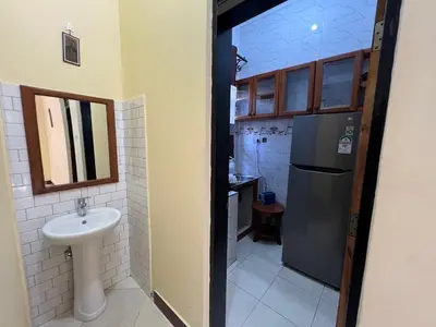 a small bathroom with a sink and a refrigerator at Beego Apartments in Arusha