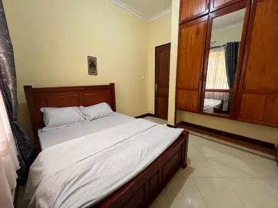 a bedroom with a bed and a large window at Beego Apartments in Arusha