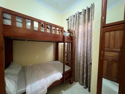 a bedroom with two bunk beds and a door at Beego Apartments in Arusha