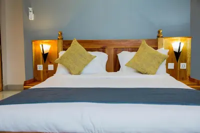 a bedroom with a large bed with white sheets and pillows at Heim Villa in Kahe