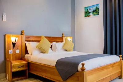 a bedroom with a wooden bed with pillows at Heim Villa in Kahe