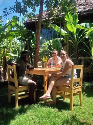 a group of three people sitting at a table at Jangwani River View Suits in Mto wa Mbu