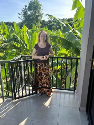 a woman standing on the balcony of a building at Jangwani River View Suits in Mto wa Mbu