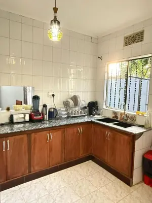 a kitchen with wooden cabinets and a sink at Logic stays 3 bedroom Arusha, Njiro in Arusha