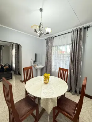 a dining room with a white table and chairs at Logic stays 3 bedroom Arusha, Njiro in Arusha