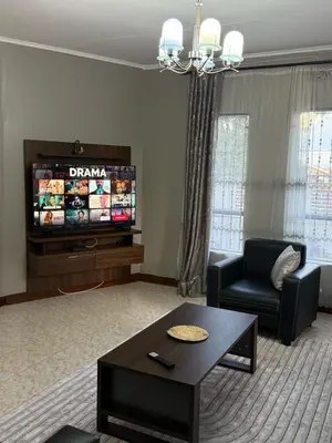 a living room with a couch and a tv at Logic stays 3 bedroom Arusha, Njiro in Arusha