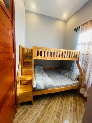 two bunk beds in a room with wooden floors at Triple s homes in Arusha