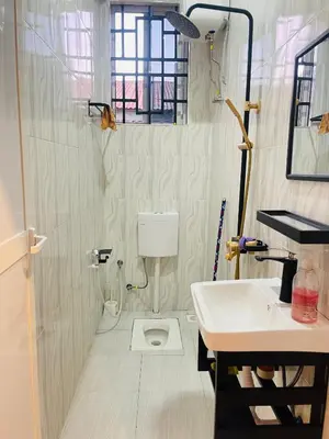 a bathroom with a sink and a toilet at Triple s homes in Arusha