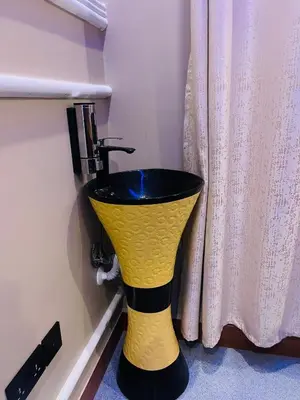 a yellow and black sink in a bathroom at Triple s homes in Arusha