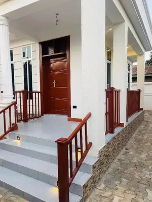 a front porch of a house with a wooden door at Triple s homes in Arusha