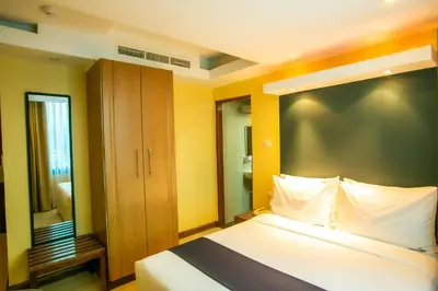 a bedroom with a large bed and a mirror at Parrot Hotel Arusha in Arusha