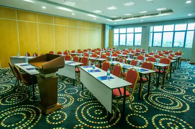 a conference room with tables and chairs and a podium at Parrot Hotel Arusha in Arusha