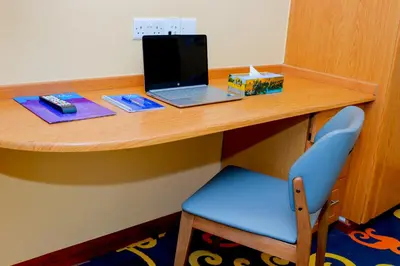 a desk with a laptop and a blue chair at Parrot Hotel Arusha in Arusha