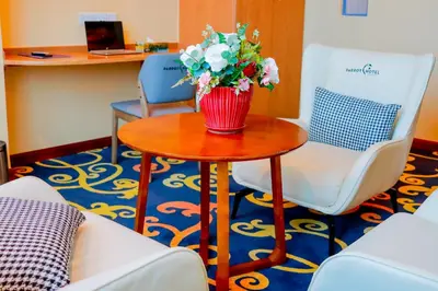 a table with a vase of flowers on it at Parrot Hotel Arusha in Arusha