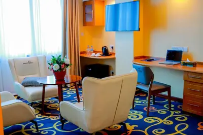a room with chairs and a table and a desk at Parrot Hotel Arusha in Arusha
