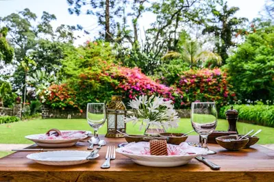 a wooden table with plates and wine glasses on it at Ngare Sero Mountain Lodge in Usa River