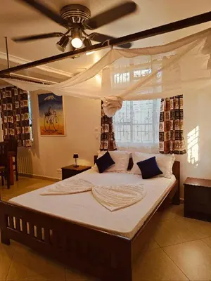a large bed in a room with a ceiling at SafariVITA Villa in Moshi
