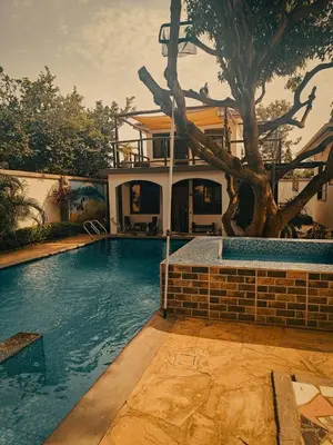 a house with a swimming pool next to a tree at SafariVITA Villa in Moshi