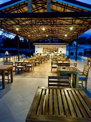 a restaurant with wooden benches and tables and a bar at Moshono Hillside in Arusha