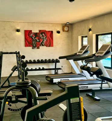 a gym with several tread machines in a room at Moshono Hillside in Arusha