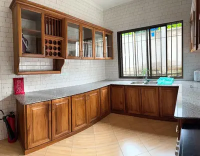 a kitchen with wooden cabinets and a sink at Moshono Hillside in Arusha